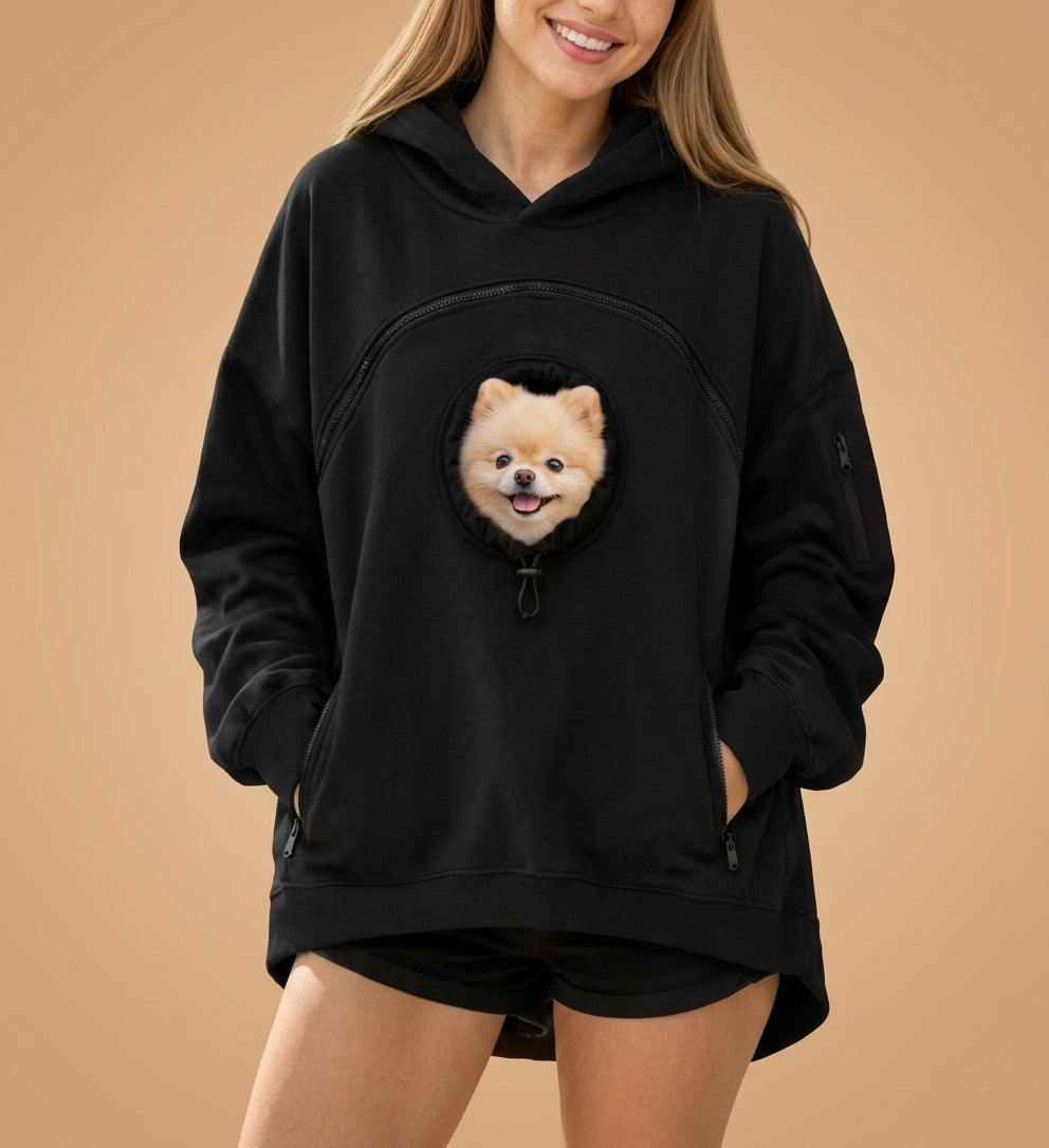 Sudadera con bolsillo para mascota en color negro, con un pomerania asomando por la ventana del bolsillo